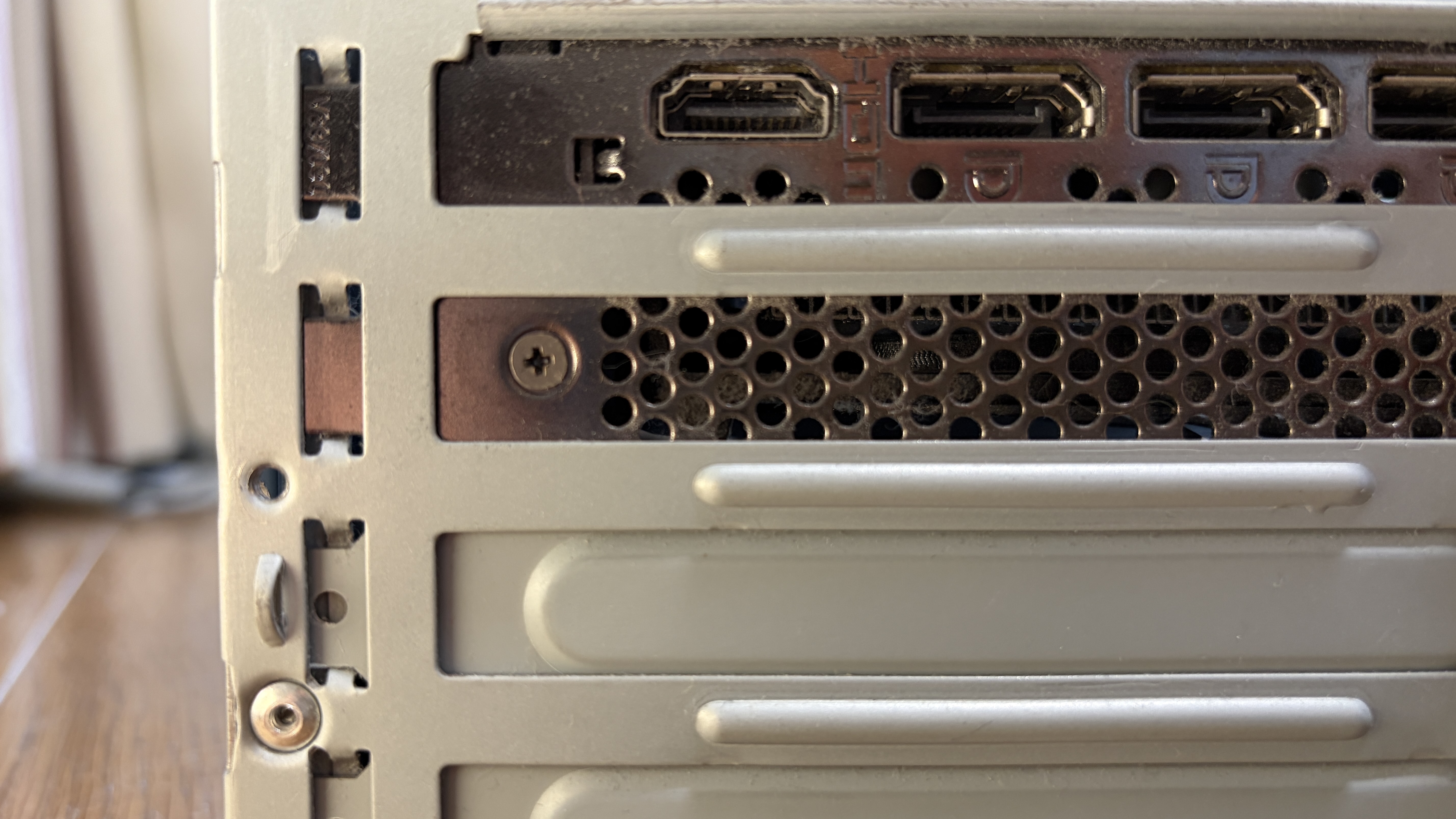 GPUの背面出力ポート（DisplayPort × 3、HDMI × 1）。ここを固定するブラケットのネジを外す。