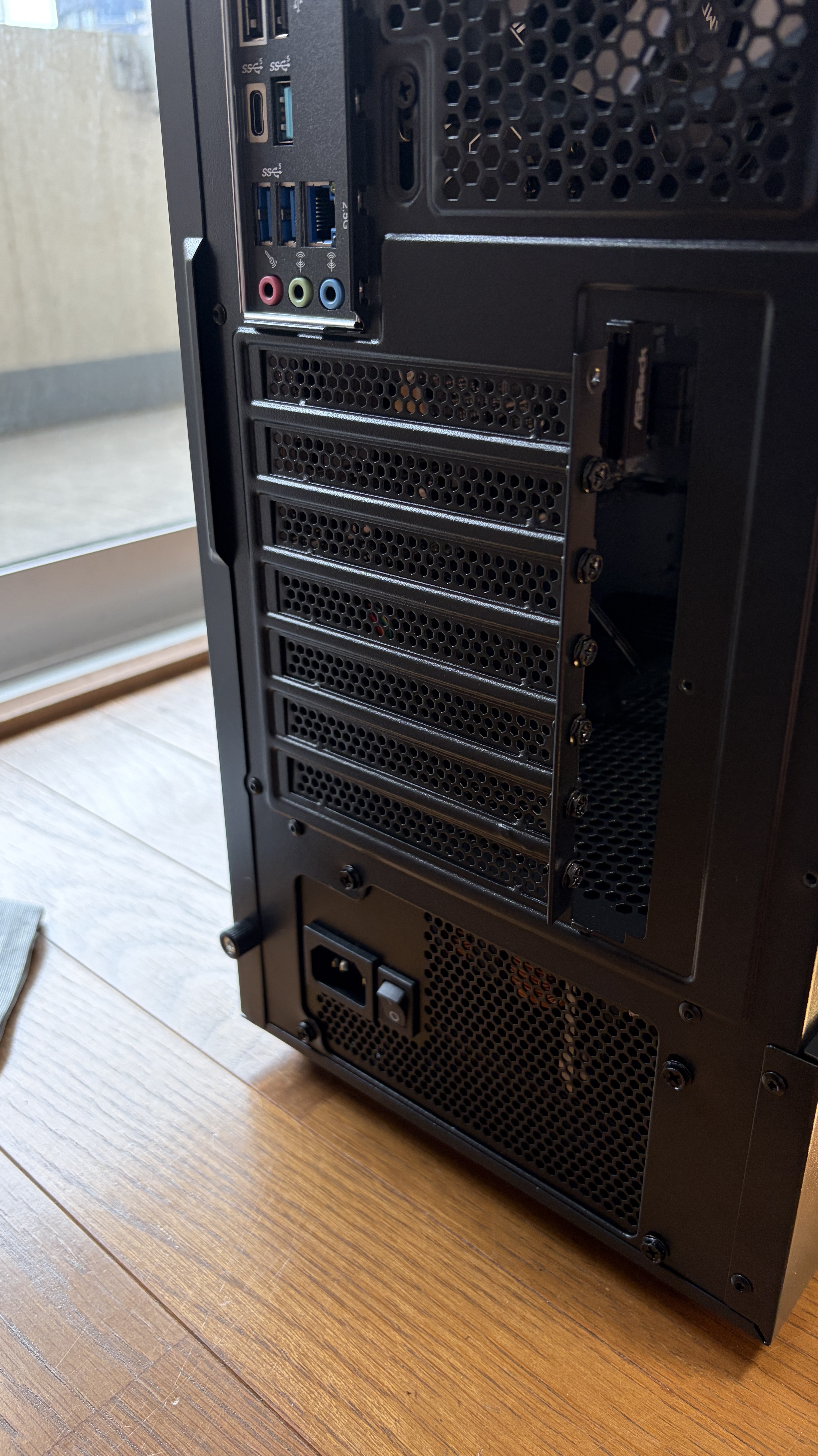 GPU取り付け前の新PC背面パネル。スロットカバーが並んで装着されている状態。ここから2スロット分を外す必要がある。