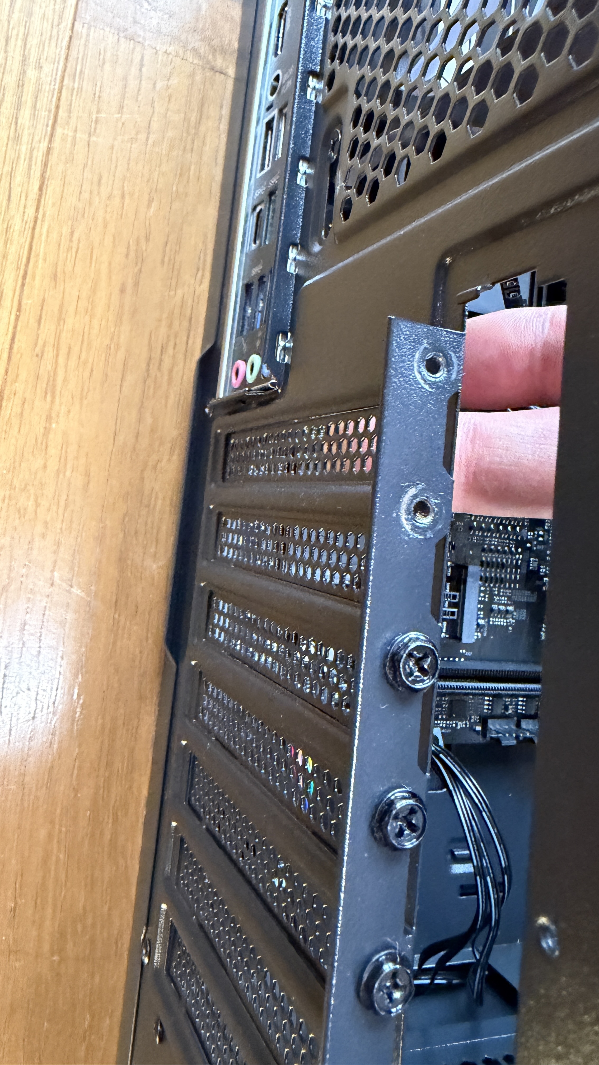 新PC背面パネルとGPUブラケットの位置合わせ。固定するためのネジ穴が見える。