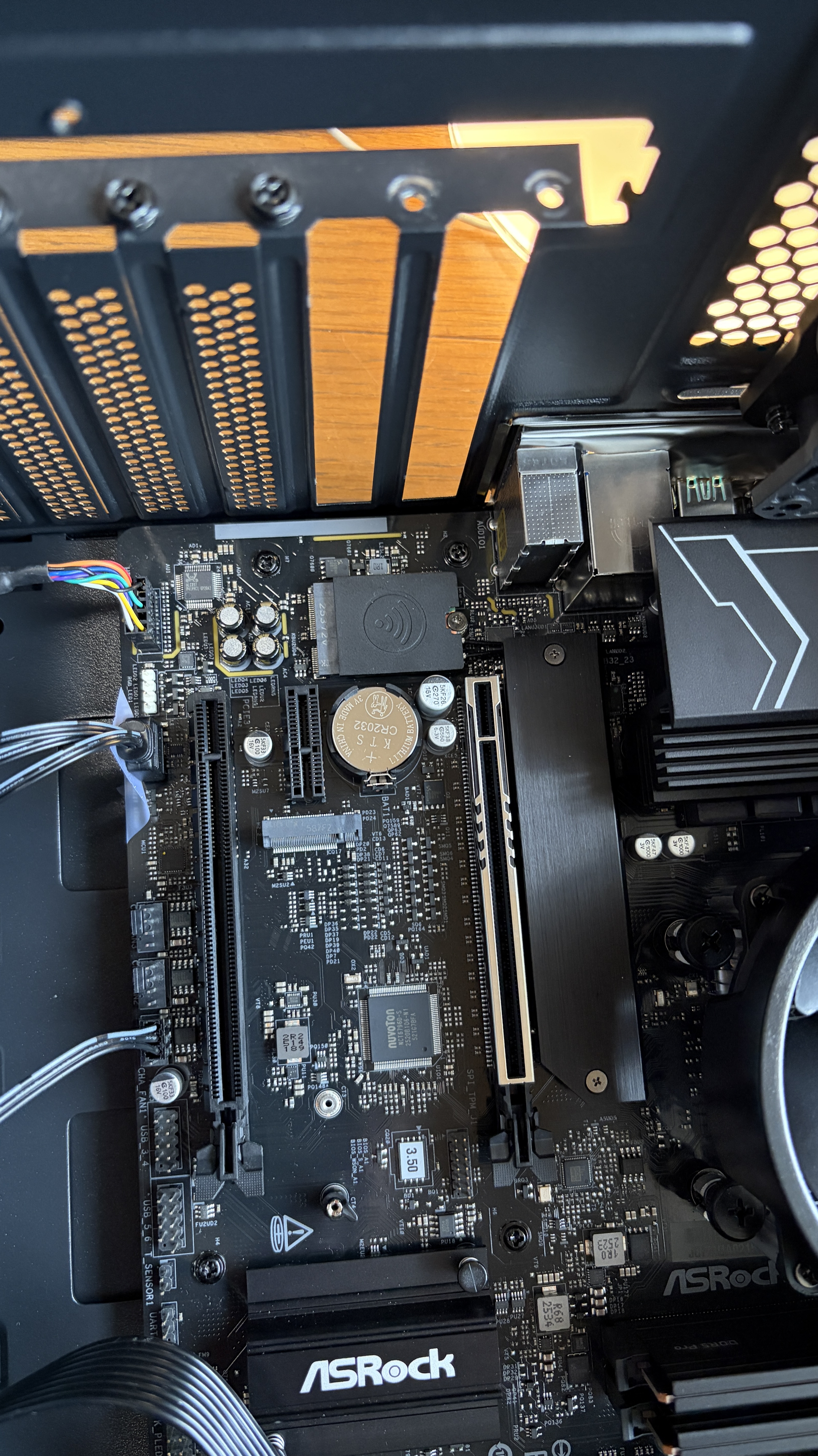 ASRockマザーボードのPCIeエリアクローズアップ。ロックレバーが奥に見える。
