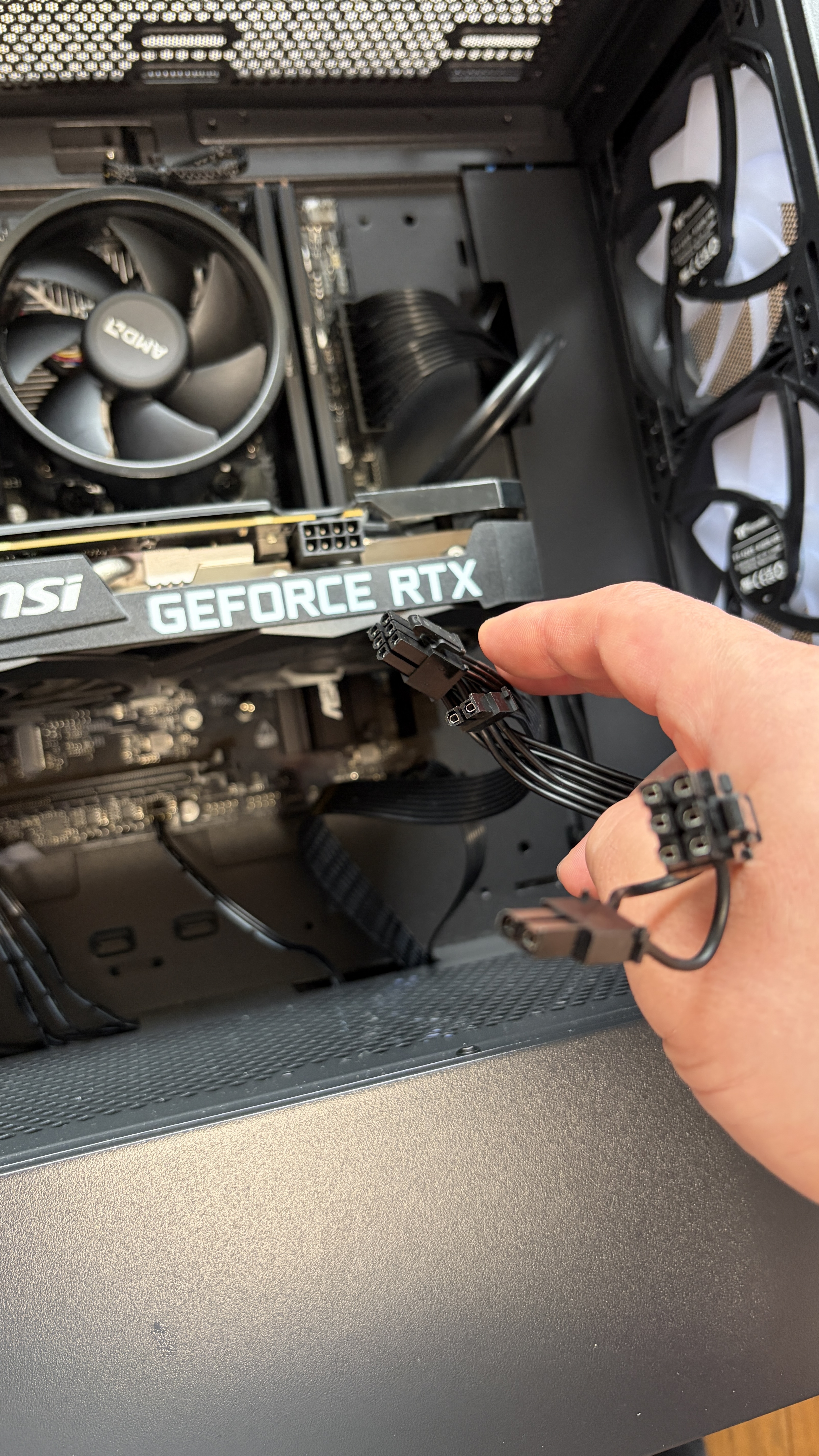 GPUのPCIe補助電源ケーブル（6+2pin）を接続している作業中。電源ユニットからのびるケーブルをGPU上部に挿す。