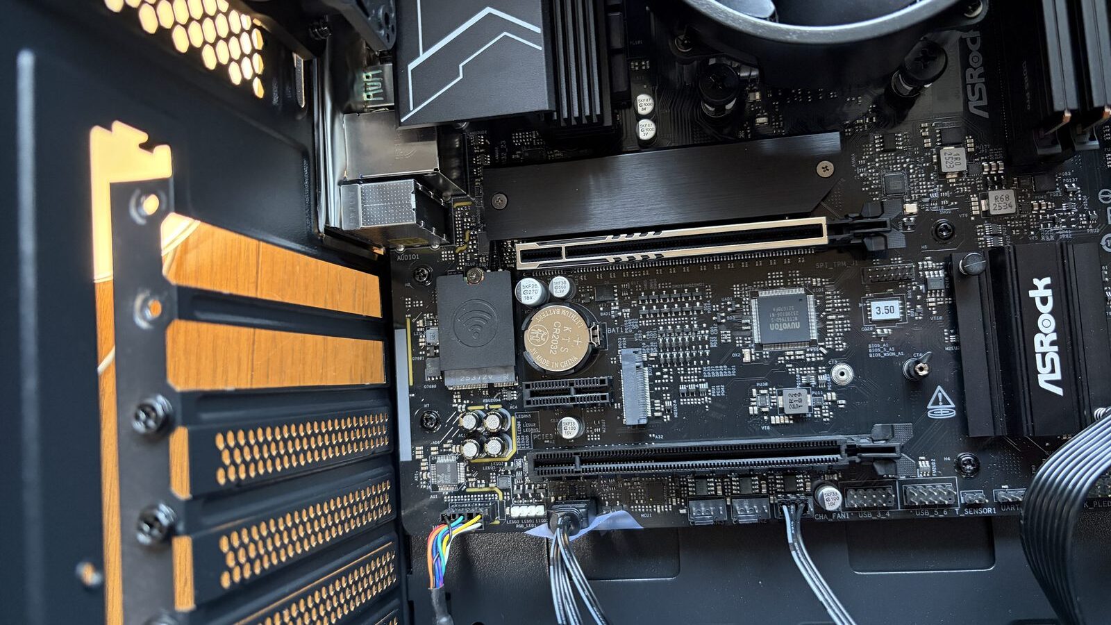 ASRockマザーボードのPCIeエリアクローズアップ。ロックレバーが奥に見える。