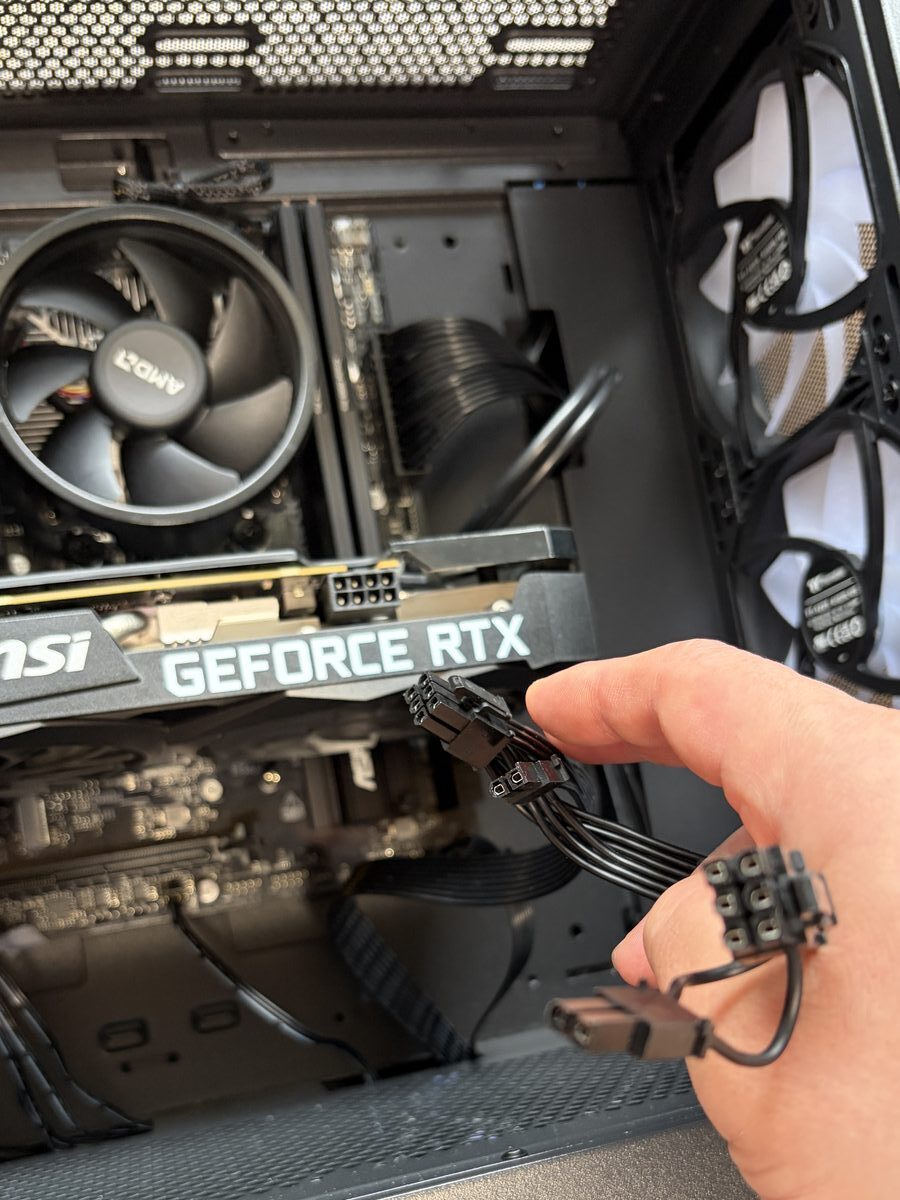 GPUのPCIe補助電源ケーブル（6+2pin）を接続している作業中。電源ユニットからのびるケーブルをGPU上部に挿す。